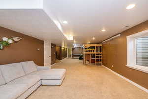 Living room featuring baseboards, carpet, recessed lighting, and a textured ceiling