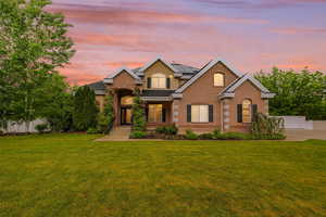 Traditional-style home with roof mounted solar panels, brick siding, and stucco siding
