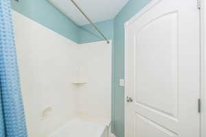 Full bath with a textured ceiling and washtub / shower combination