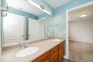 Full bathroom featuring double vanity and baseboards