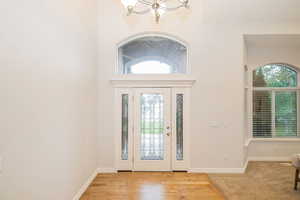 Foyer with a chandelier and baseboards