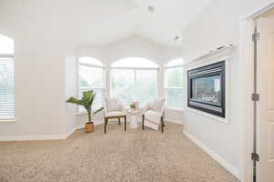 Sitting room with carpet, vaulted ceiling, and baseboards