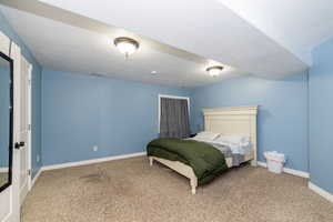 Bedroom with carpet flooring, baseboards, and a textured ceiling