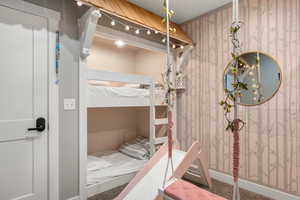 Carpeted bedroom with wallpapered walls