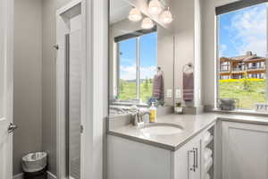 Full bath featuring vanity and a shower stall