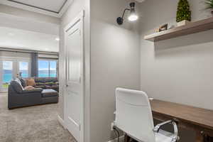 Home office featuring carpet, ornamental molding, and french doors