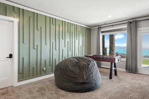 Living area with carpet flooring, a water view, and ornamental molding
