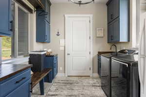 Laundry room with independent washer and dryer, cabinet space, and light tile patterned floors