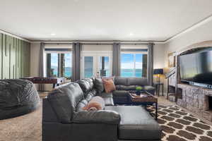 Living area featuring crown molding, carpet floors, french doors, and healthy amount of natural light