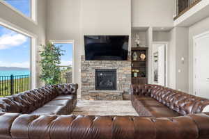 Living area with a towering ceiling, a fireplace, and built in shelves