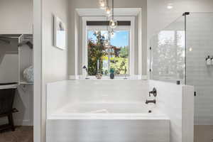 Full bath with a bath, a stall shower, and a walk in closet