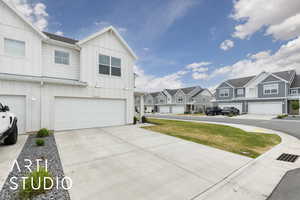 View of front of home with board and batten siding, a residential view, an attached garage, and driveway