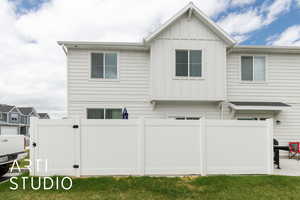 Back of property featuring board and batten siding and fence