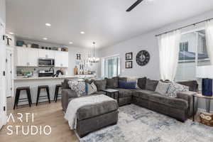 Living room with a chandelier, light wood-style flooring, ceiling fan, and recessed lighting