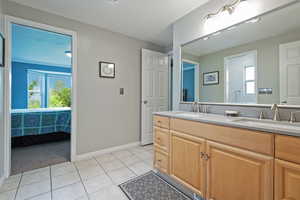 Full bath with tile patterned flooring, baseboards, and double vanity