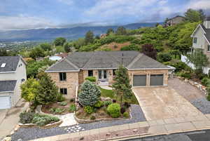 View of front of property featuring french doors, brick siding, a garage, a mountain view, and concrete driveway