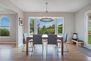 Dining space featuring a chandelier, light wood finished floors, and baseboards