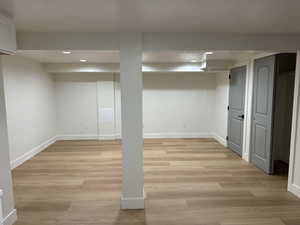 Finished below grade area with recessed lighting, baseboards, and light wood-style floors