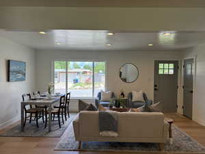 Living area featuring baseboards, light wood-style flooring, and recessed lighting