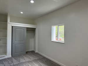 Unfurnished bedroom featuring recessed lighting, carpet flooring, a closet, and baseboards