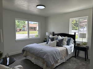 Bedroom featuring dark carpet and baseboards