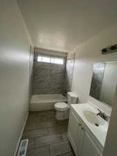 Bathroom with toilet, vanity, shower / bathtub combination, and baseboards