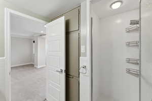 Hall featuring light colored carpet and baseboards