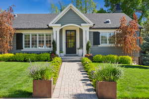 Single story home with a front lawn, a chimney, and roof with shingles