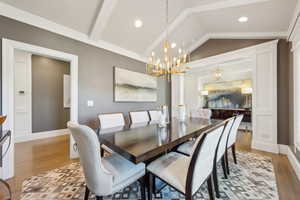 Dining area with vaulted ceiling, light wood-style flooring, a chandelier, recessed lighting, and baseboards