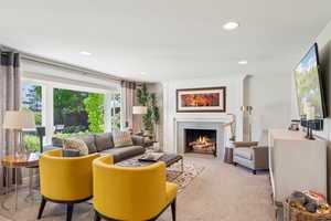 Carpeted living room featuring a fireplace with flush hearth and recessed lighting