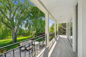 Balcony featuring an outdoor living space, a porch, and view of scattered trees