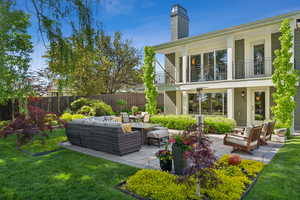 Rear view of house with outdoor lounge area, a chimney, and brick siding