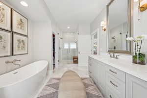 Bathroom with a shower stall, vanity, recessed lighting, a freestanding tub, and a walk in closet