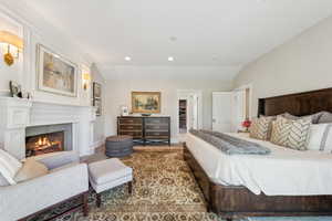 Bedroom with recessed lighting, a glass covered fireplace, lofted ceiling, and baseboards