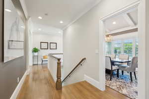Hallway featuring an upstairs landing, a chandelier, light wood-style flooring, crown molding, and recessed lighting