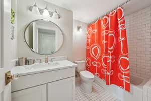 Bathroom with toilet, vanity, and shower / bath combo