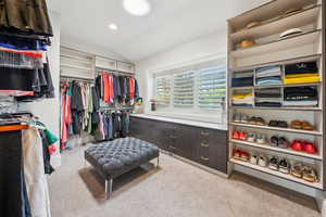 Spacious closet with light carpet and vaulted ceiling