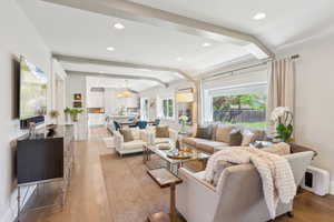 Living area featuring a chandelier, light wood finished floors, lofted ceiling, and recessed lighting