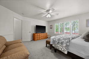 Carpeted bedroom featuring ceiling fan
