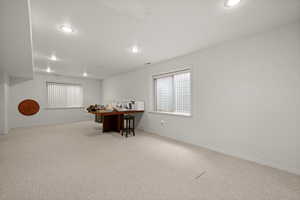 Carpeted dining space with recessed lighting, baseboards, and a desk
