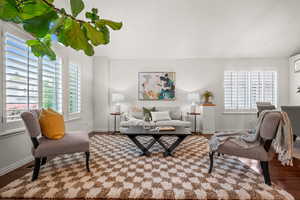 Living room with wood finished floors, healthy amount of natural light, and baseboards