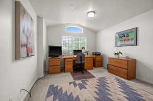 Office with light colored carpet, lofted ceiling, and baseboards