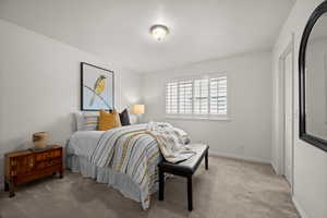 Bedroom with light colored carpet and baseboards