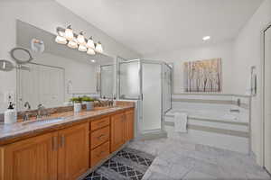 Bathroom featuring double vanity, a shower stall, a garden tub, and recessed lighting