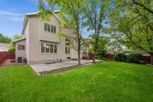 Back of property with stucco siding, central AC unit, and a patio