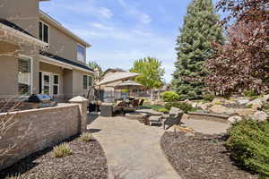 View of patio / terrace with an outdoor fire pit, fence, an outdoor kitchen, and area for grilling