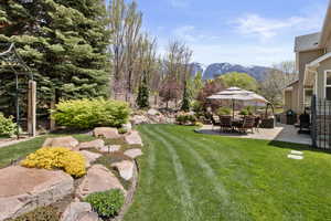 View of yard with fence, a patio, and a mountain view