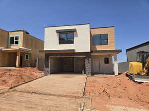 View of front of house featuring driveway, stucco siding, and an attached garage