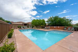 Community pool featuring a patio area and fence