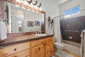 Full bath featuring toilet, vanity, shower / bathtub combination with curtain, and tile patterned flooring